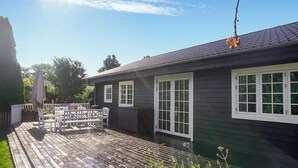 A house with a deck, white-framed windows, and a dark roof. - 4 bedroom gorgeous home in Karrebæksminde (Karrebæksminde)