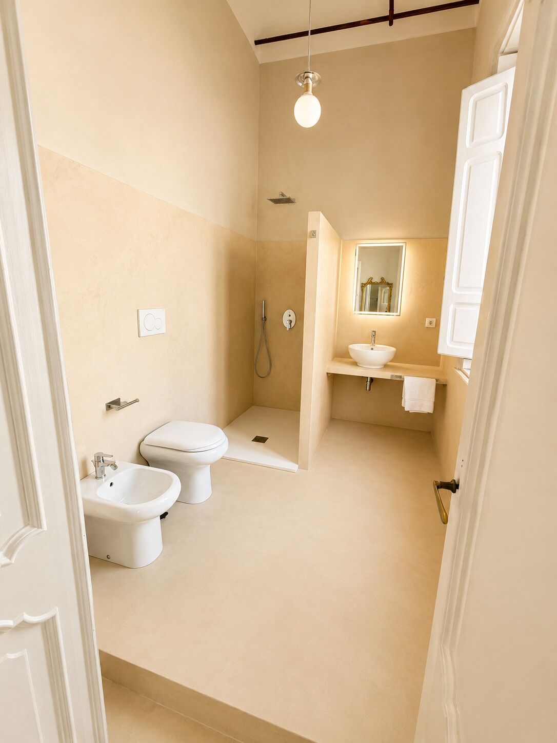 A compact bathroom with a toilet, bidet, and shower.