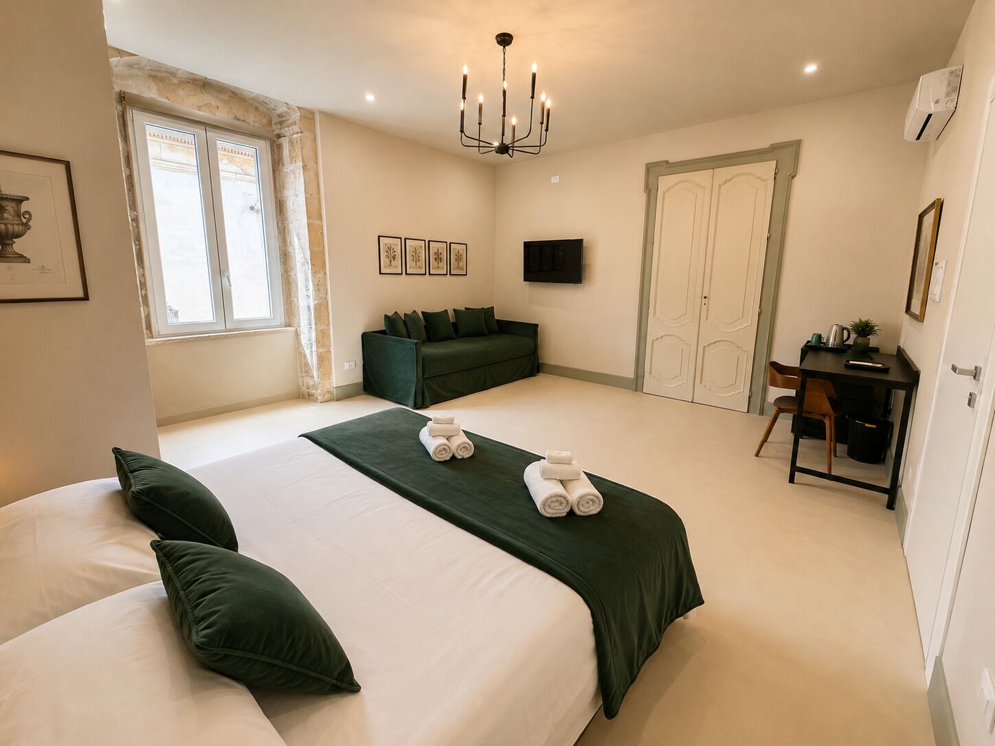 Una habitación de hotel con una cama grande, un escritorio, un sofá y un televisor.