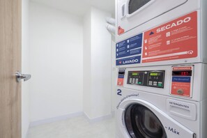 A laundry facility with a washing machine, a dryer, and a control panel with instructions. - New Loft near Milla de Oro with AC and coworking (Medellín)