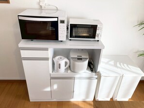 Eine Küchenzeile mit Mikrowelle, Toaster und Wasserkocher.