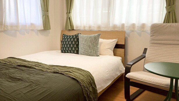 A hotel room with a bed, a chair, and curtains. - Neo Universal 05 (Osaka, Konohana, Nishikujo)