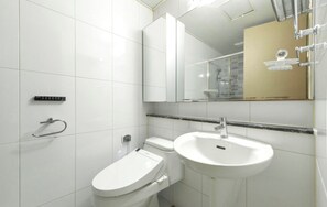 Une salle de bain moderne équipée de toilettes, d’un bidet et d’un lavabo.