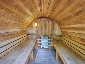 Een sauna met houten banken en een bankje met een handdoekhouder.