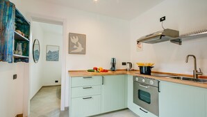 A compact kitchen with a stove, sink, and a small countertop. - La Porte Rouge 100 Mt From Lake Maggiore (Meina)