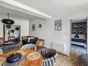Ein modernes Wohnzimmer mit Essbereich, ausgestattet mit einem runden Tisch, Stühlen und einer Couch.