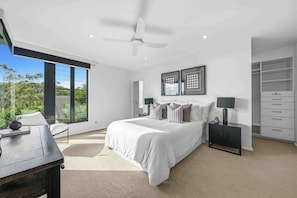 A bedroom with a bed, a desk, a chair, a wardrobe, and a window with a view of greenery. - Burleigh Vista, Burleigh Heads (Burleigh Heads)