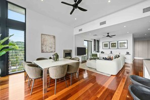 A spacious living area with a dining table, sofas, and a TV. - Burleigh Vista, Burleigh Heads (Burleigh Heads)