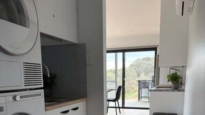 Eine moderne Küche mit integrierten Geräten, ein Essbereich mit Blick und ein großes Fenster.