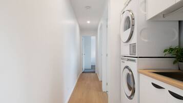A laundry room with a washing machine, dryer, and a sink.