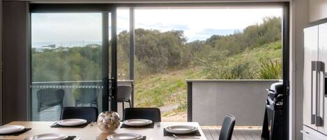 A dining area with a table set for four, overlooking a natural landscape.