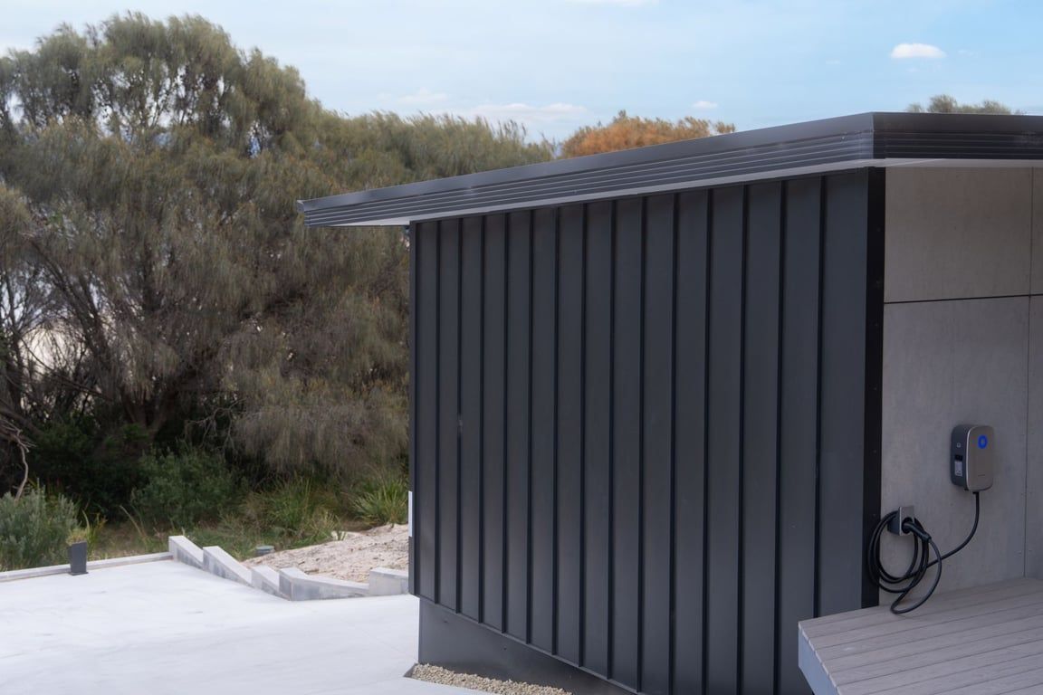 A modern building with a flat roof and a power outlet on the side.