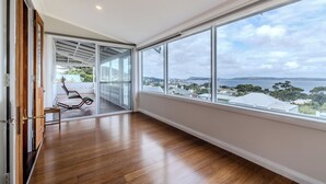 Una habitación amplia con un gran ventanal que ofrece vistas a un paisaje costero.
