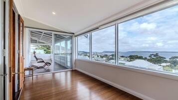 Quarto espaçoso com uma grande janela e vista para a paisagem costeira.