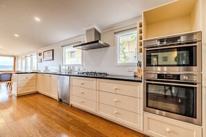 Una cocina moderna con estufa a gas, electrodomésticos de acero inoxidable y lavavajillas.