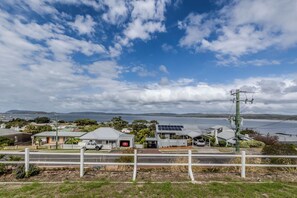 A coastal residential area with houses, a road, and a body of water in the background. - Blue Horizon by The BNB Collection (Albany)