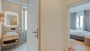 A modern bathroom with a marble sink, a mirror, and a built-in light. - Residenza Tilia (Mesocco)