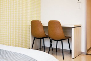 A room with a bed, a desk with two chairs, and a patterned wall. - PortSide Avenue  (Fukuoka City Hakataku  Tsumashoji)