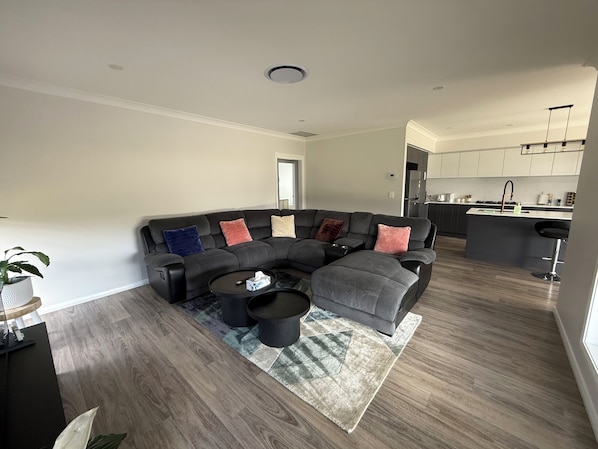 A modern living room with a sectional sofa, a coffee table, and a rug.