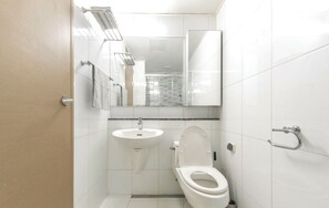 Un baño pequeño y moderno con inodoro, lavamanos y espejo.