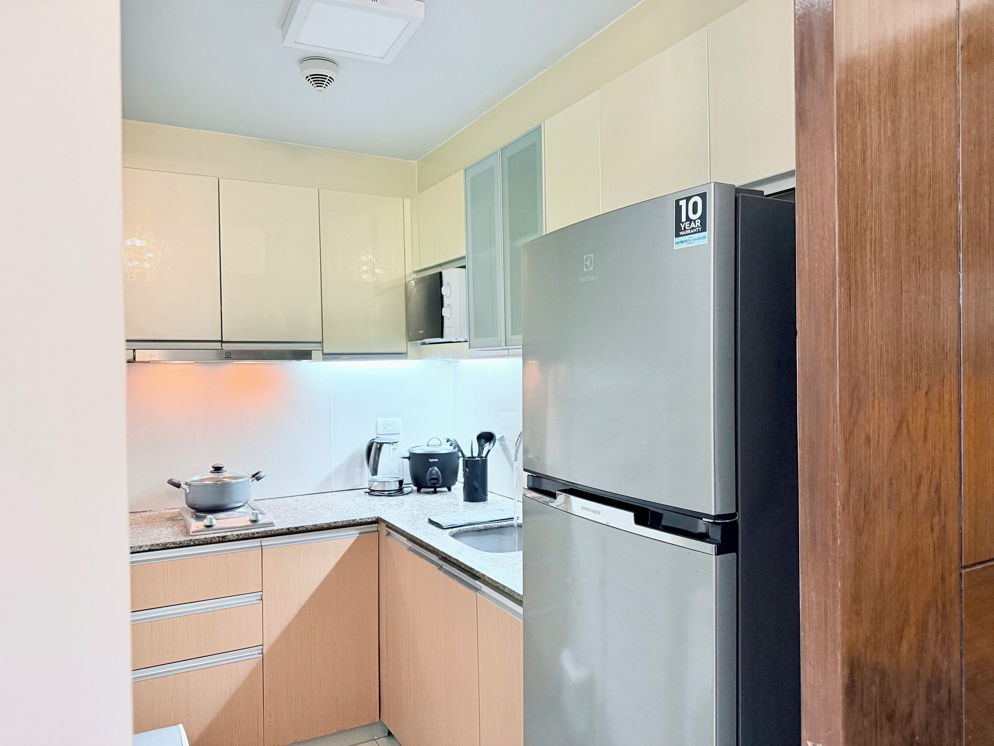 A kitchen with a stainless steel refrigerator, a microwave, and a coffee maker on the counter.