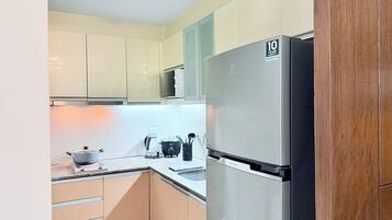 A kitchen with a stainless steel refrigerator, a microwave, and a coffee maker on the counter.