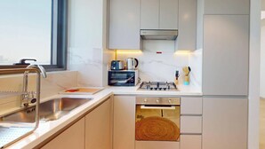 Eine moderne Küche mit Einbauofen, Gasherd und Kaffeemaschine.