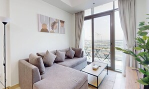 A modern living room with a sofa, a coffee table, and artwork on the wall. - Chic 1BR with Canal View (Dubai)