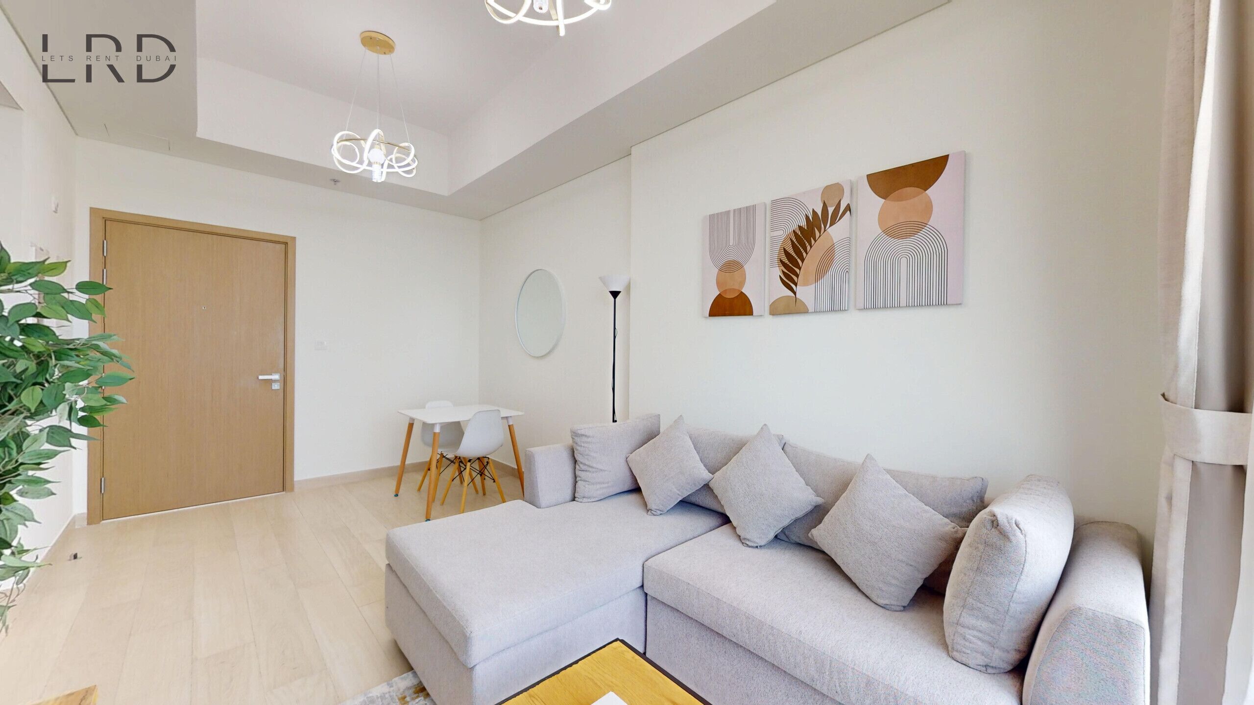 A modern living room with a sectional sofa, a small table, and a floor lamp.