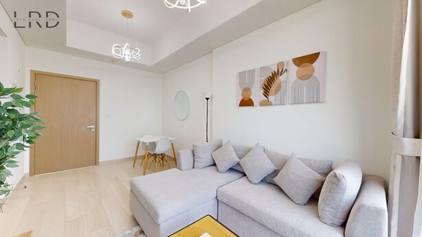 Ein modernes Wohnzimmer mit einem Ecksofa, einem kleinen Tisch und einer Stehlampe.