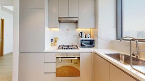 Eine moderne Küche mit Backofen, Gasherd und Mikrowelle.