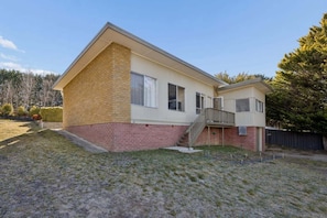 Ein einstöckiges Haus mit Ziegel Fassade und einer kleinen angebauten Garage.