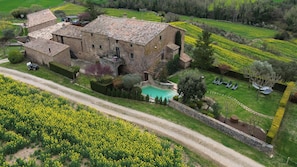 A large stone building with a swimming pool and a garden.