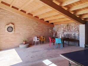 A room with a dartboard, a table, chairs, and a ping pong table. - CHARMING COUNTRY HOUSE (Montmajor)
