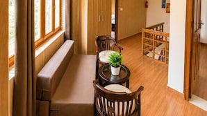 A room with a seating area, wooden flooring, and a ceiling light fixture.