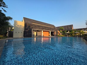 A modern building with a swimming pool in front. - LaBriza By SanLiving - 2BR - PIK2 (Kosambi)