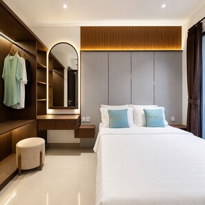 Ein modernes Schlafzimmer mit einem großen Bett, einem eingebauten Kleiderschrank, einem Schminktisch mit Spiegel und einem runden Hocker.