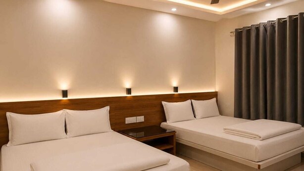 Una habitación de hotel con dos camas, cabecero de madera, mesitas de noche y una cortina.
