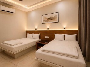 Habitación de hotel con dos camas individuales, cabecera de madera, mesita de noche y aire acondicionado instalado en la pared.
