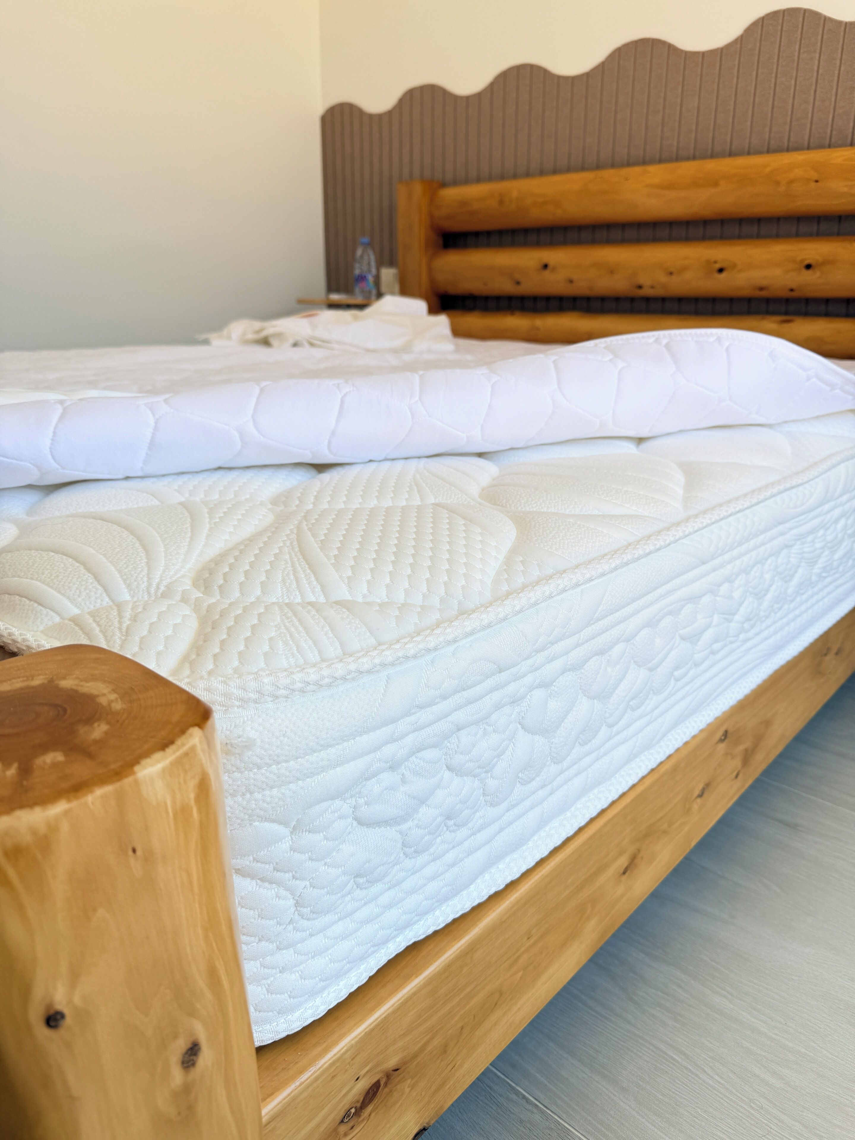 A wooden bed frame with a mattress and pillows.