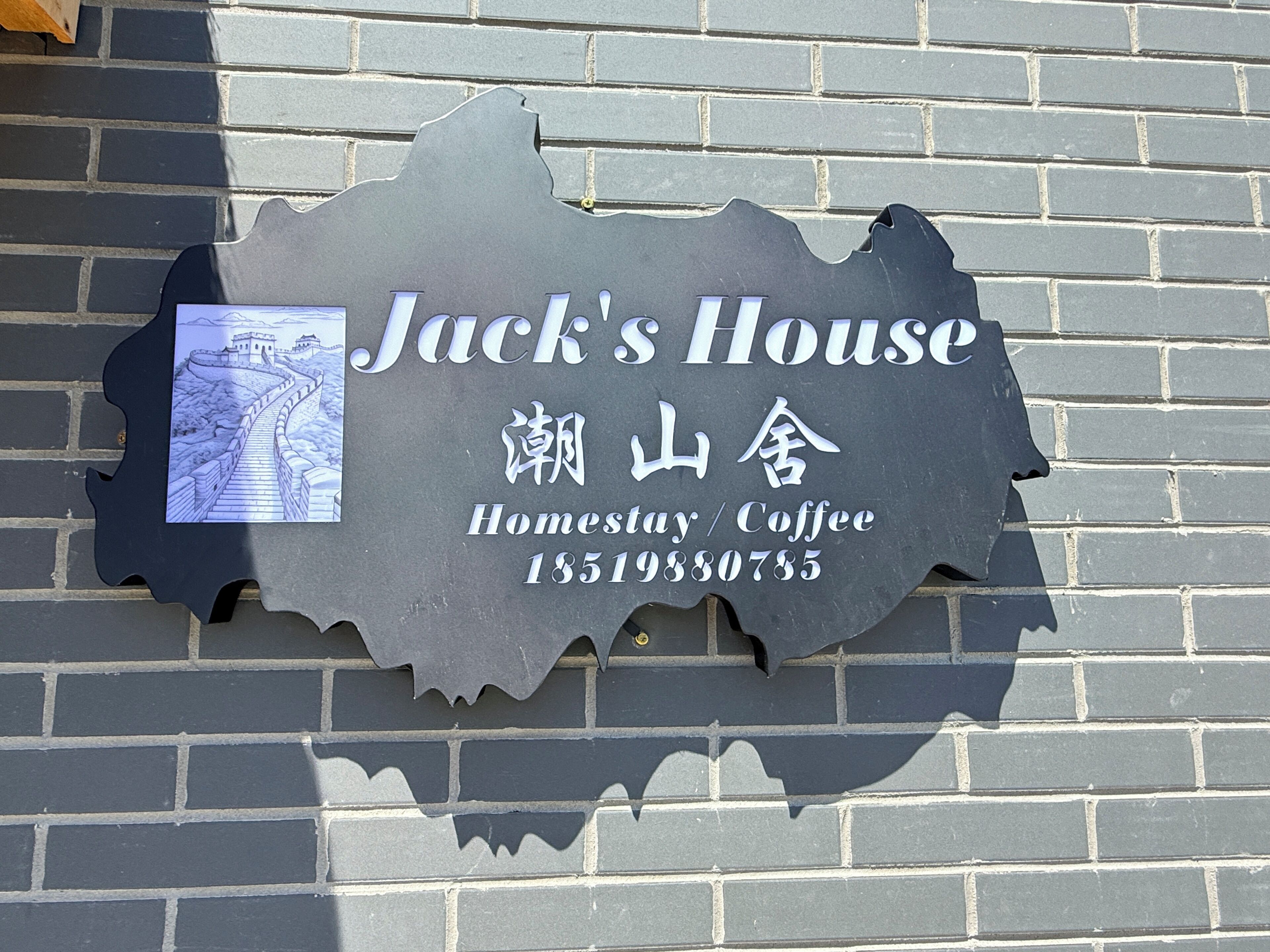 Placa com o nome 'Jack's House', um mapa e um número de contato.