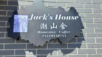 Placa com o nome 'Jack's House', um mapa e um número de contato.