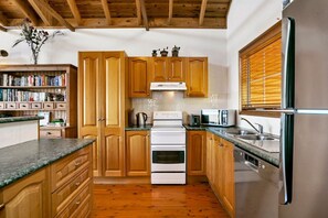 Eine Küche mit Holzausstattung, einem weißen Herd, einer Spüle und einem Kühlschrank.