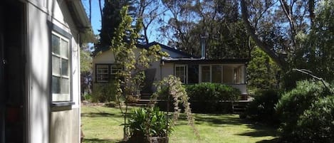 A residential property with a detached house, a small shed, and a well-maintained lawn.