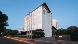 Un hotel moderno con fachada blanca, amplias ventanas y un logotipo destacado.