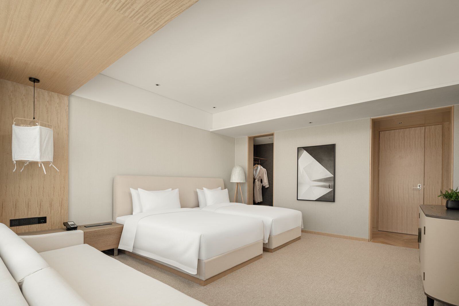Een moderne hotelkamer met een groot bed, nachtkastjes, een kledingkast en een spiegel.