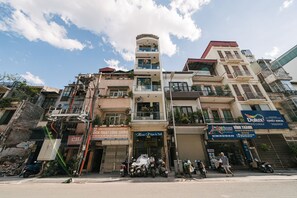 A multi-story building with various commercial establishments on the ground floor, including a nail salon and a hair salon. - Anora de Van-Luxury 1-bedroom apartment near Ha Noi train station-Private Floor (Hà Nội)