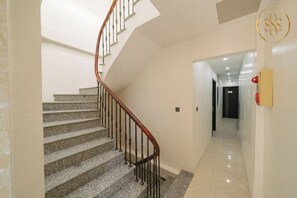 A staircase with a wooden handrail and metal balusters leading to a landing. - Anora de Van-Luxury 1-bedroom apartment near Ha Noi train station-Private Floor (Hà Nội)
