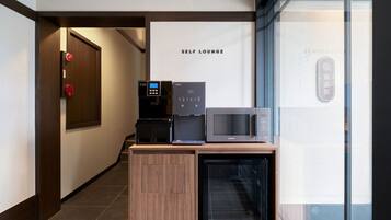 Un área de descanso con máquina de café, microondas y refrigerador.