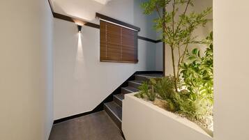 A modern staircase with a built-in planter containing various plants.